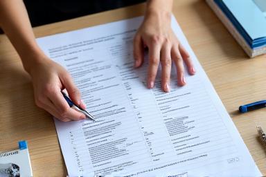 Une personne organisant des documents sur un bureau, représentant le soutien administratif.